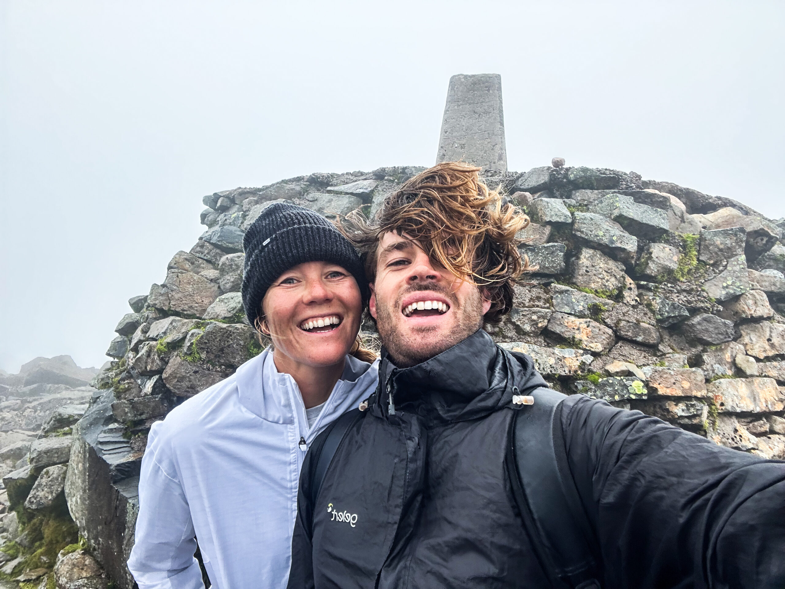 James and Lieselot stood onto of the highest mountain in the UK. Windswept and wet. 