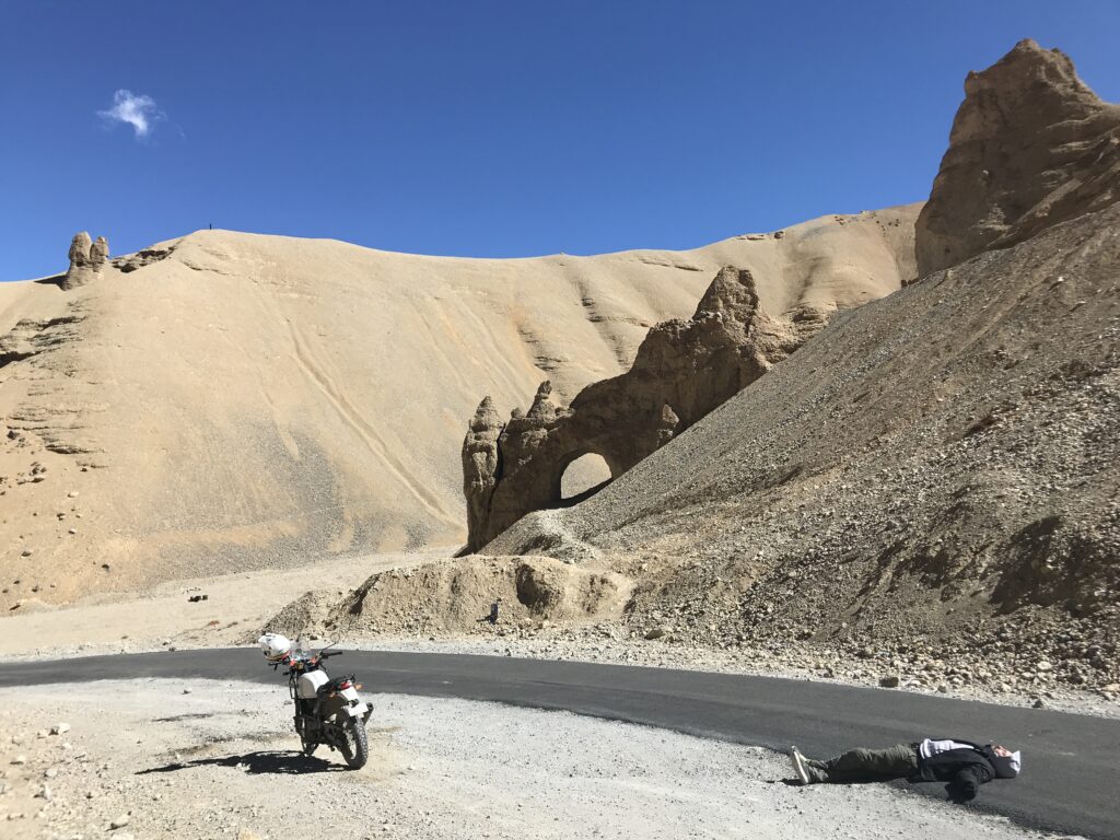 Motorbike rider laying on the floor in the Indian desert, resembling a Martian landscape.