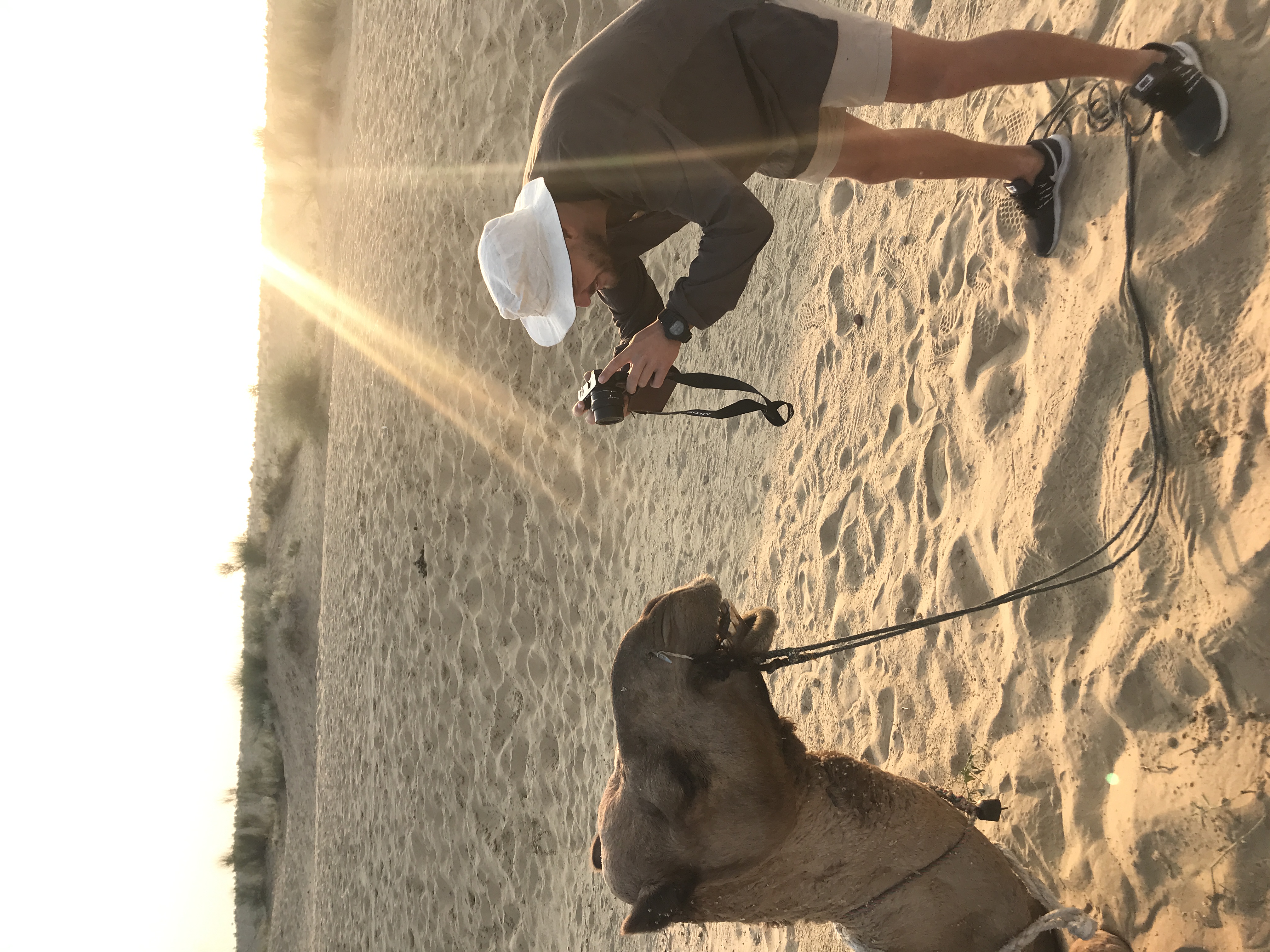 A photo of Andraes taking a close up photo of a camel in the Indian desert. 