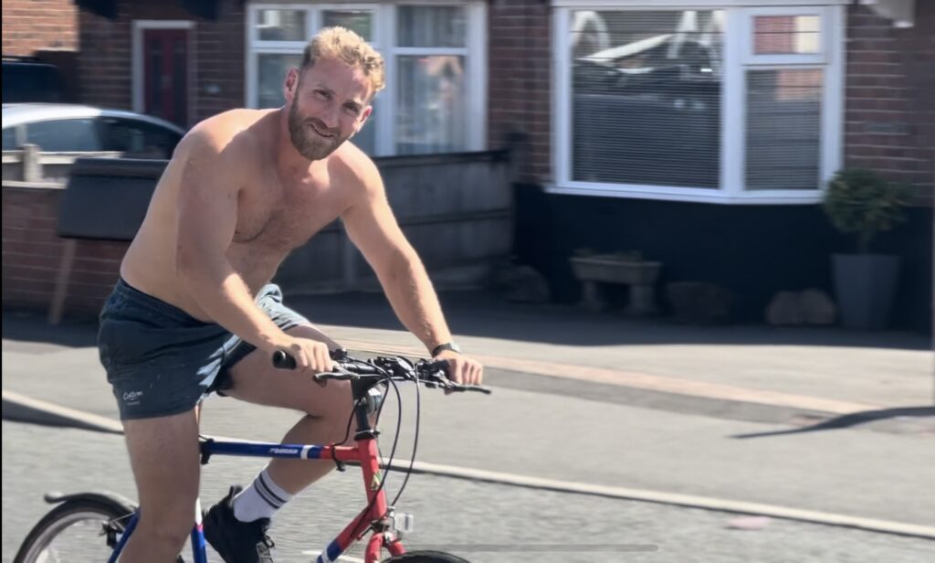 Topless Man (Louis) riding one of the bikes in the street.