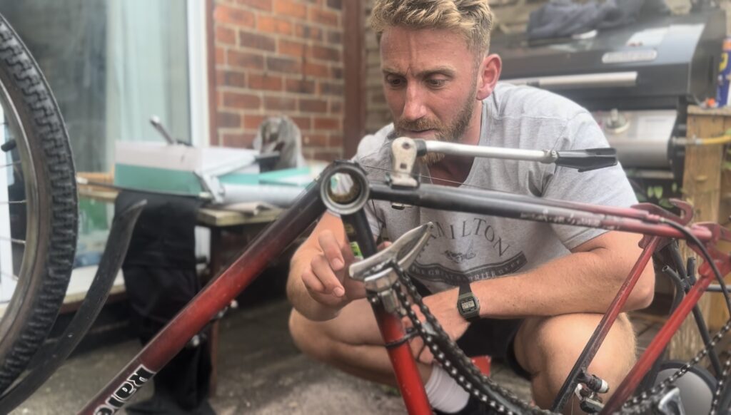 Man delicately greasing the inner bearings of a bicycle drive train